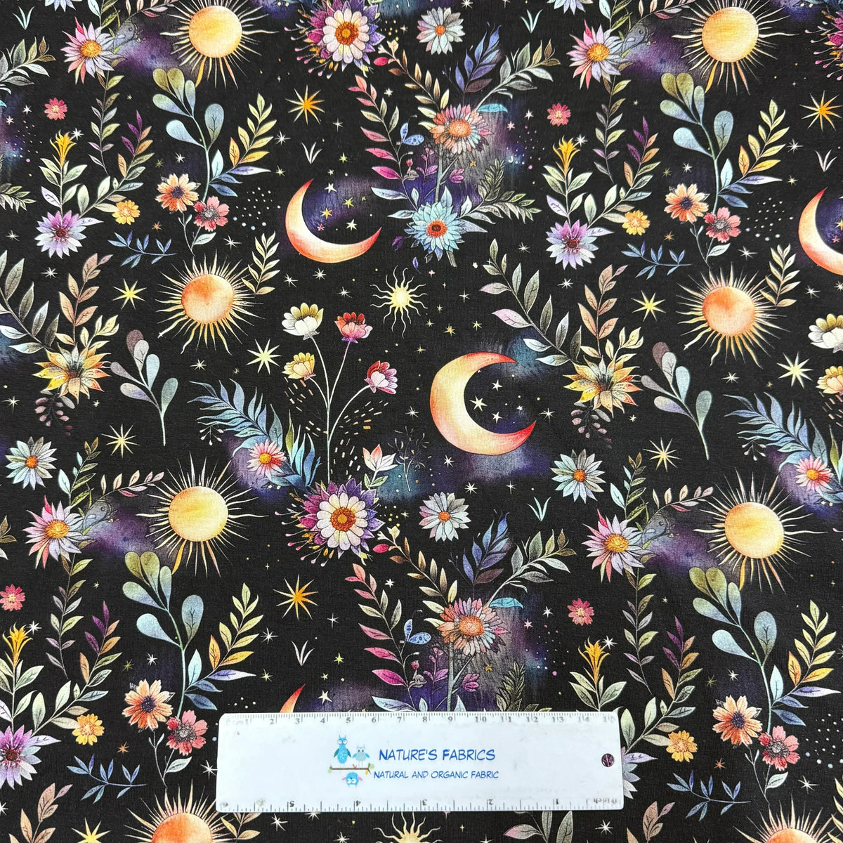 Nature's Fabrics celestial organic cotton fabric with moons, suns, and floral patterns