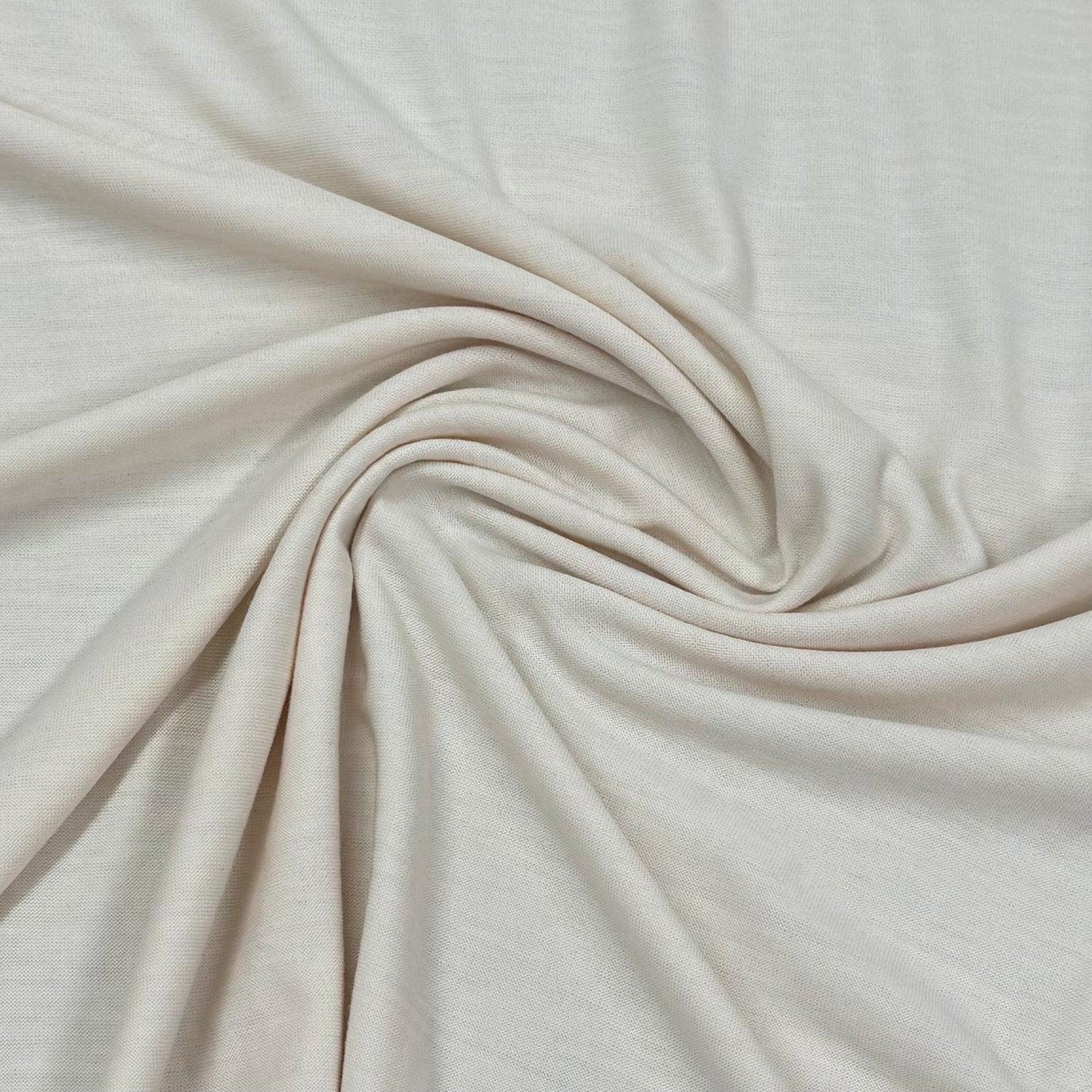 Nature's Fabrics organic cotton fabric swirled in soft folds, natural off-white textile by the yard
