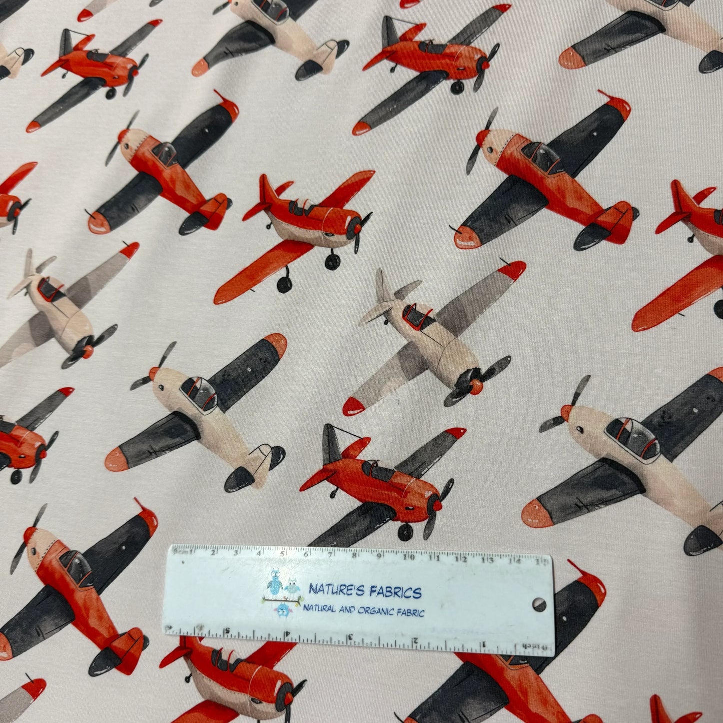 Nature's Fabrics organic cotton fabric with red and beige airplane print, eco-friendly textile