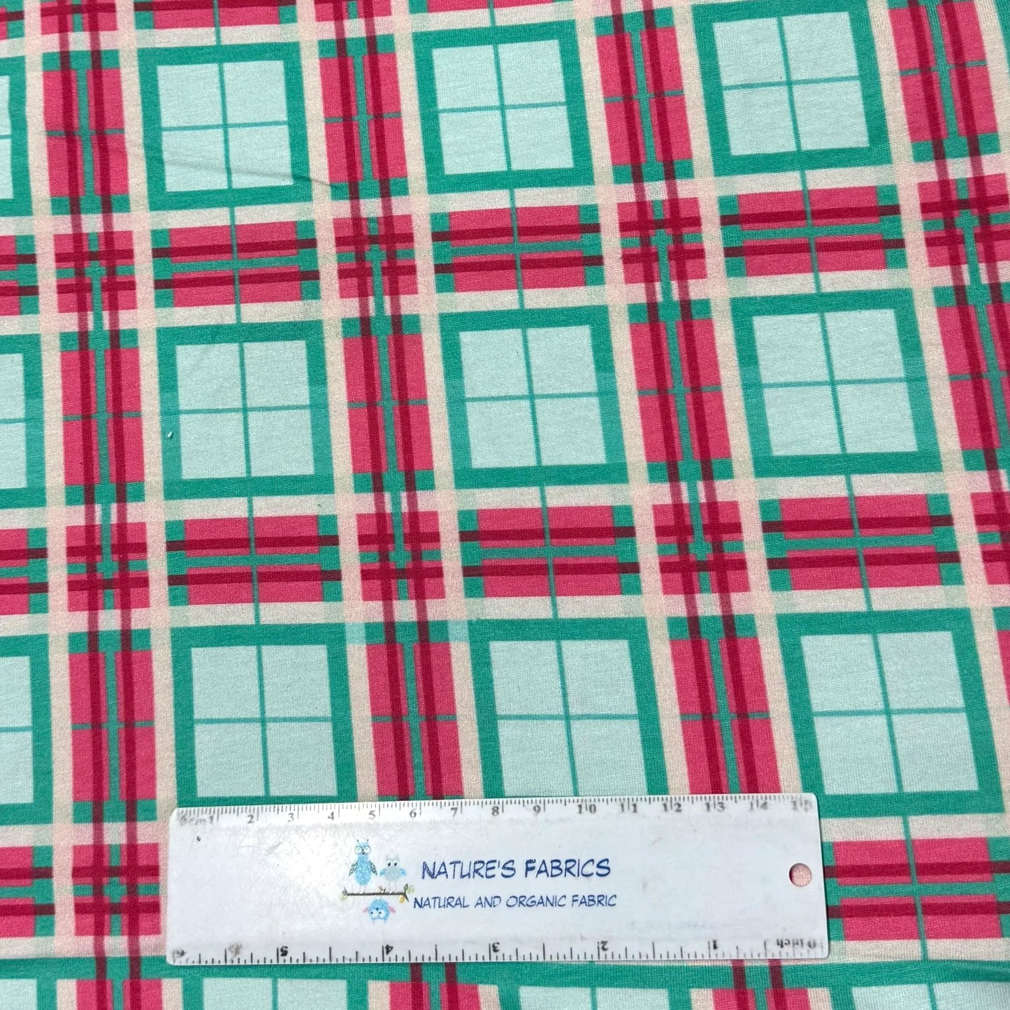 Nature's Fabrics plaid cotton fabric with green, pink, and white geometric pattern, ruler for scale