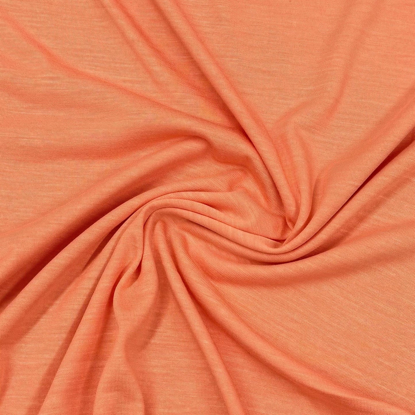 Soft coral organic cotton fabric by Nature's Fabrics, eco-friendly textile with gentle swirls and natural texture
