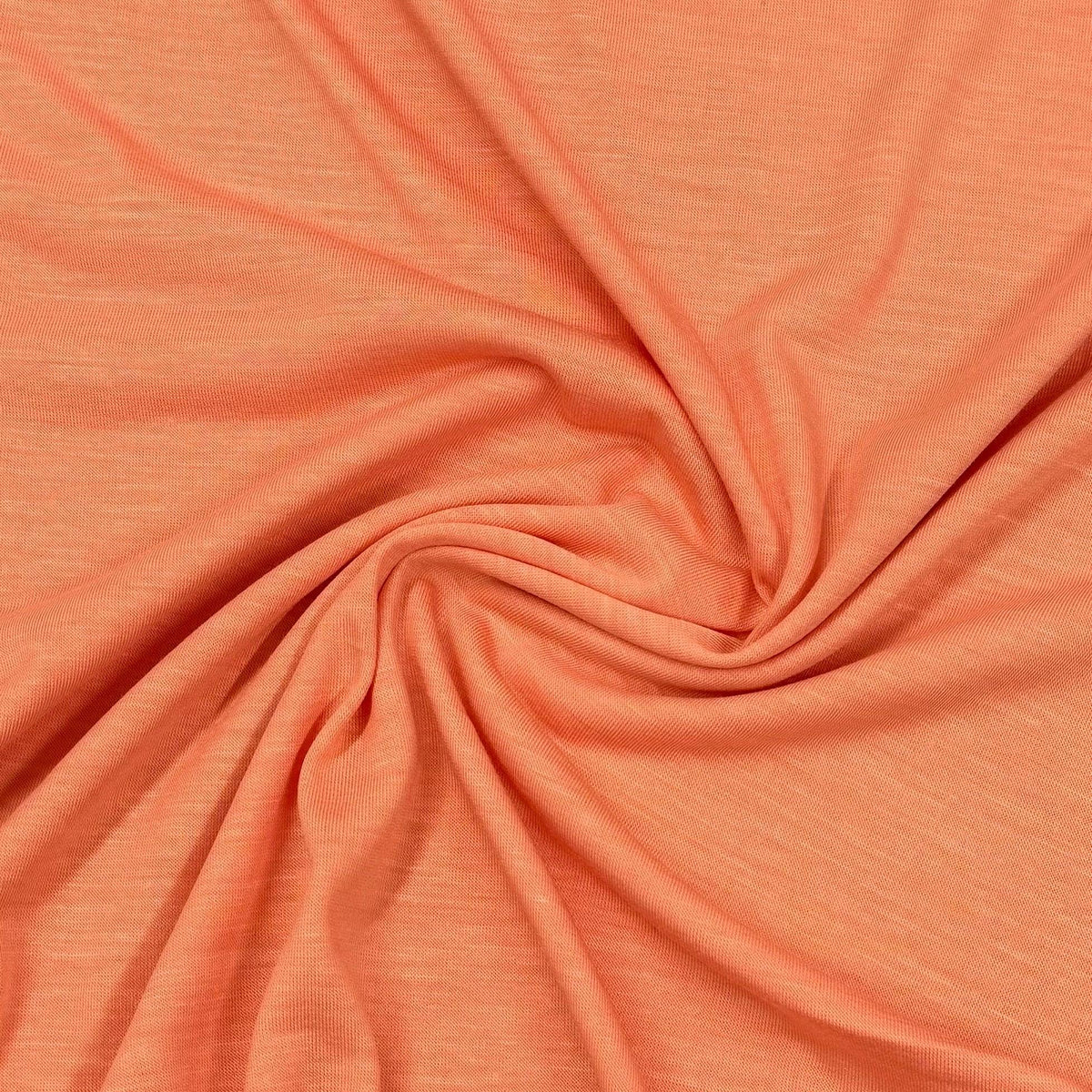 Soft coral organic cotton fabric by Nature's Fabrics, eco-friendly textile with gentle swirls and natural texture