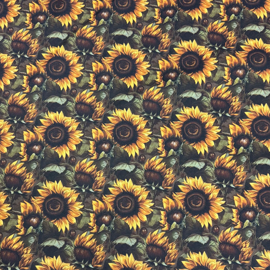 Nature's Fabrics sunflower print fabric with yellow blossoms and green leaves.