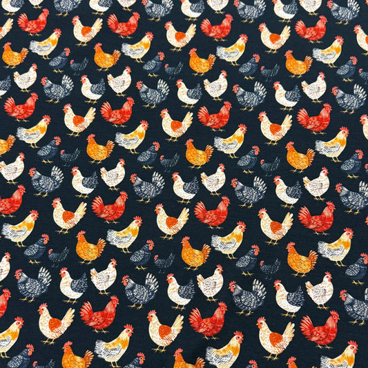Nature's Fabrics navy blue organic cotton fabric featuring a colorful pattern of chickens.