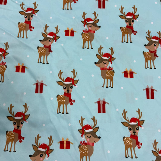 Festive reindeer print fabric with Santa hats and gifts by Nature's Fabrics
