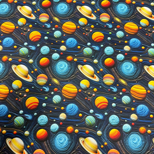 Nature's Fabrics space-themed textile featuring colorful planets and stars on a dark blue background