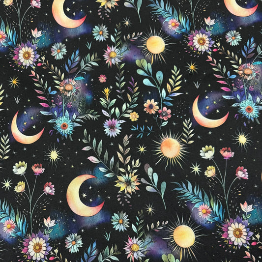Nature's Fabrics celestial pattern fabric with moons, suns, stars, and colorful floral elements.