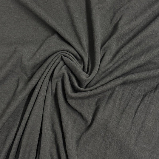 Nature's Fabrics charcoal grey organic cotton fabric draped in a swirl