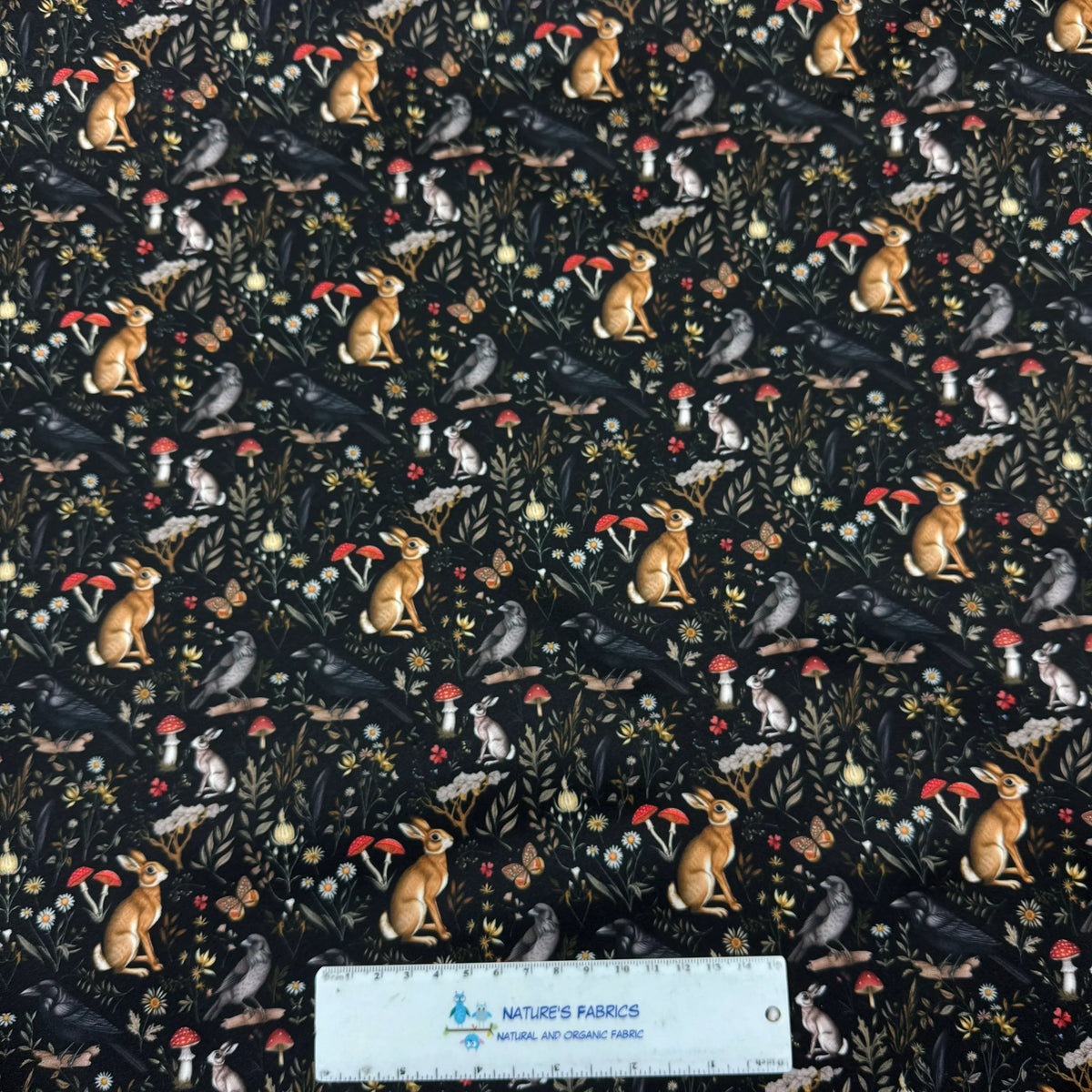 Nature's Fabrics organic cotton fabric with woodland bunnies, mushrooms, and birds on black background