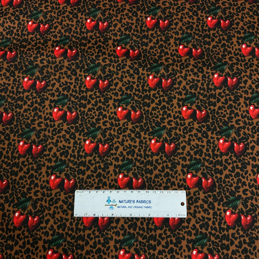 Nature's Fabrics leopard print fabric with red cherries and a measuring ruler.