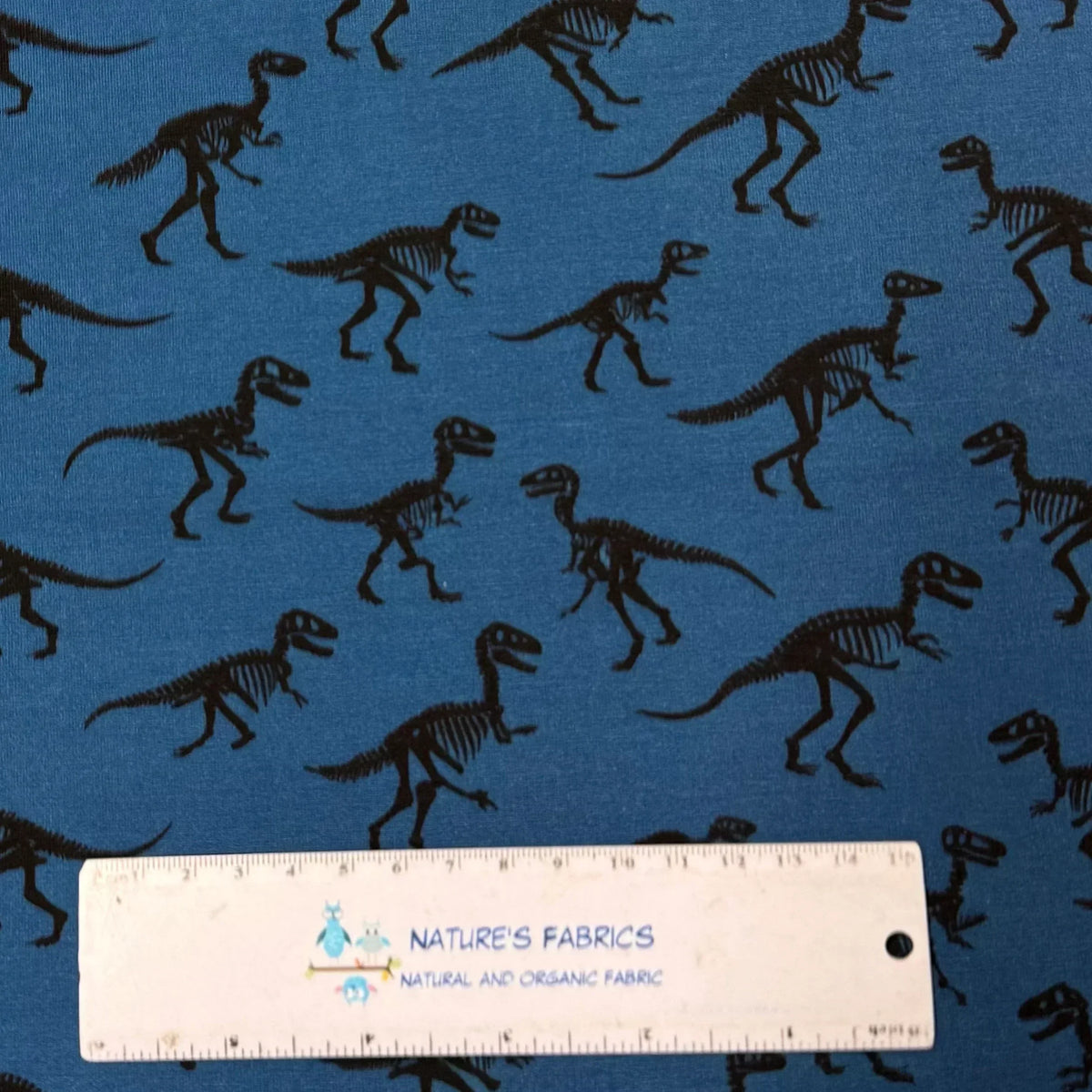 Blue fabric with black dinosaur skeleton print by Nature's Fabrics, natural organic cotton yardage