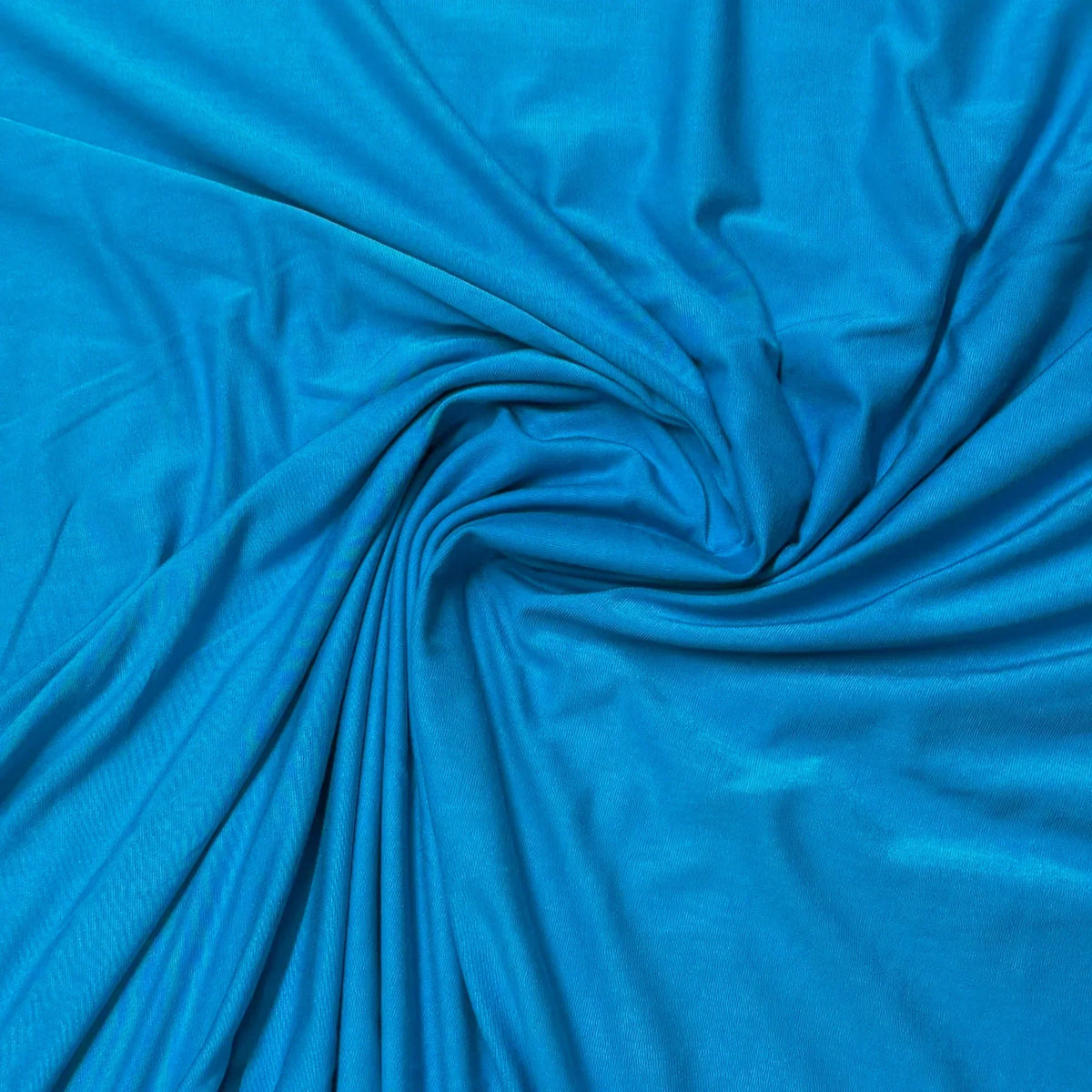 Vibrant blue organic cotton fabric swirled in soft folds — Nature's Fabrics