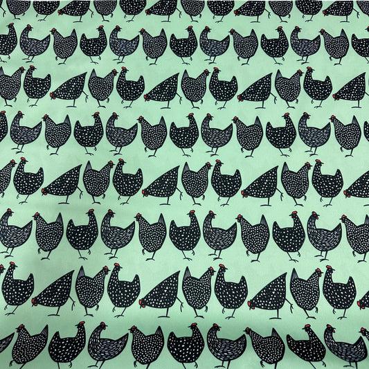 Nature's Fabrics light green organic cotton fabric with a black polka dot chicken pattern.