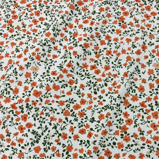 Nature's Fabrics white organic cotton fabric with a small red and orange floral print