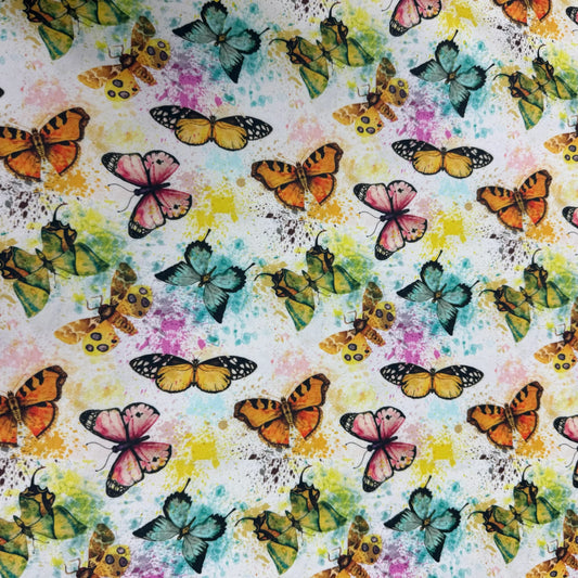 Nature's Fabrics colorful butterfly print on a white splatter background.