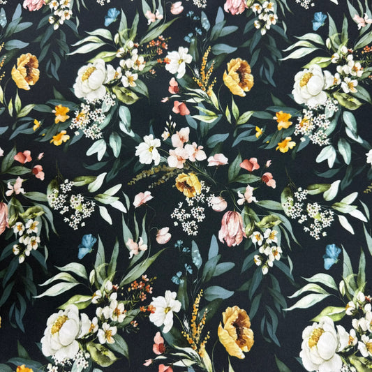 Nature's Fabrics floral print fabric with white, yellow, and pink flowers on a dark background