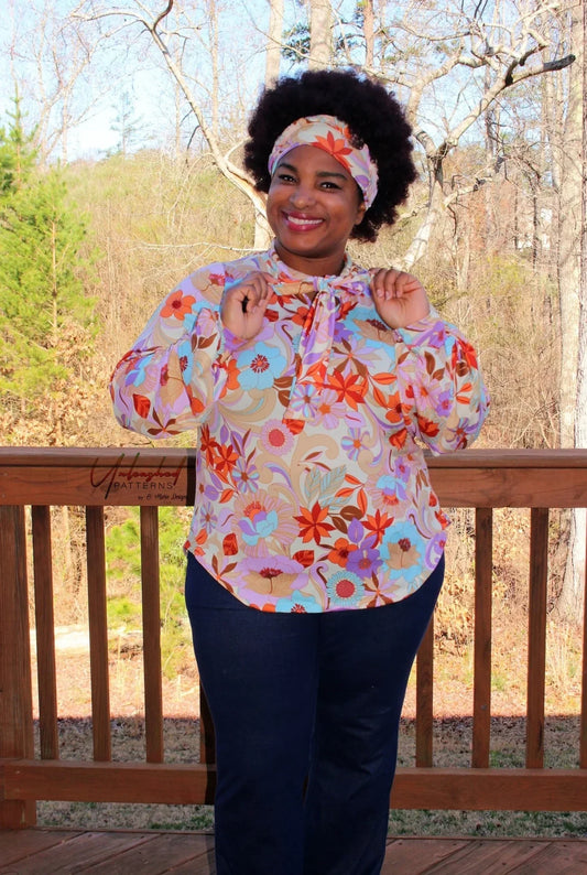 Woman wearing floral print blouse with tie neck and matching headband, Nature's Fabrics