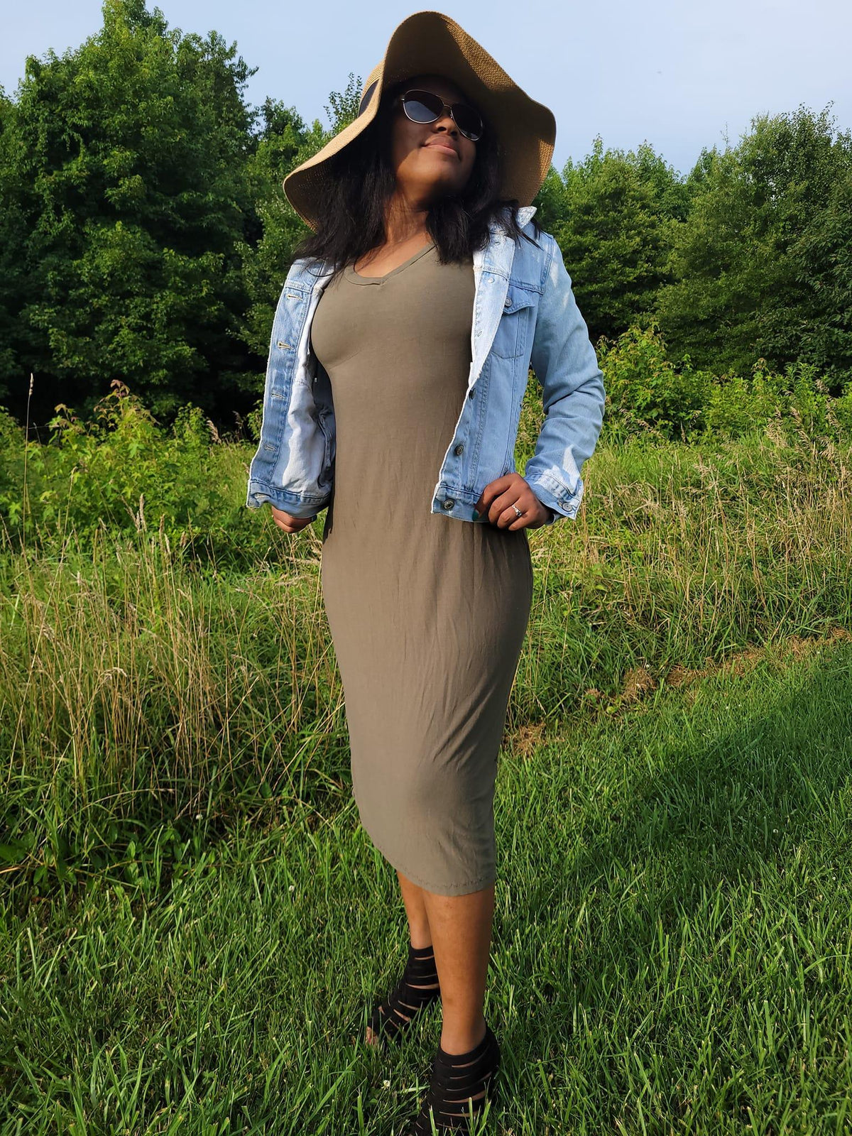 Woman in olive midi dress, denim jacket, wide-brim hat — Nature's Fabrics