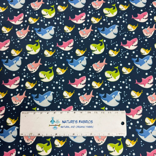 Nature's Fabrics organic cotton fabric with colorful cartoon shark pattern and ruler.