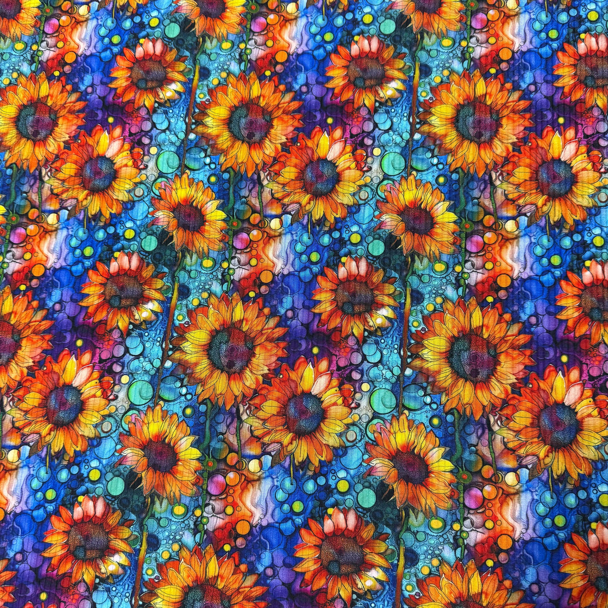 Vibrant sunflower print fabric by Nature's Fabrics, featuring bold orange blooms on a blue bubbly background.