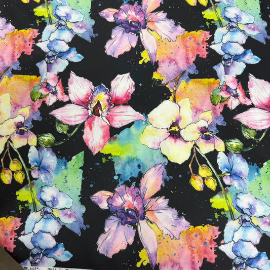 Nature's Fabrics watercolor floral print fabric with pink, purple, and blue orchids on black.