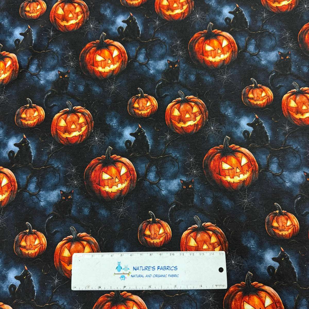 Halloween fabric with glowing jack-o'-lanterns, black cats, and spiderwebs by Nature's Fabrics