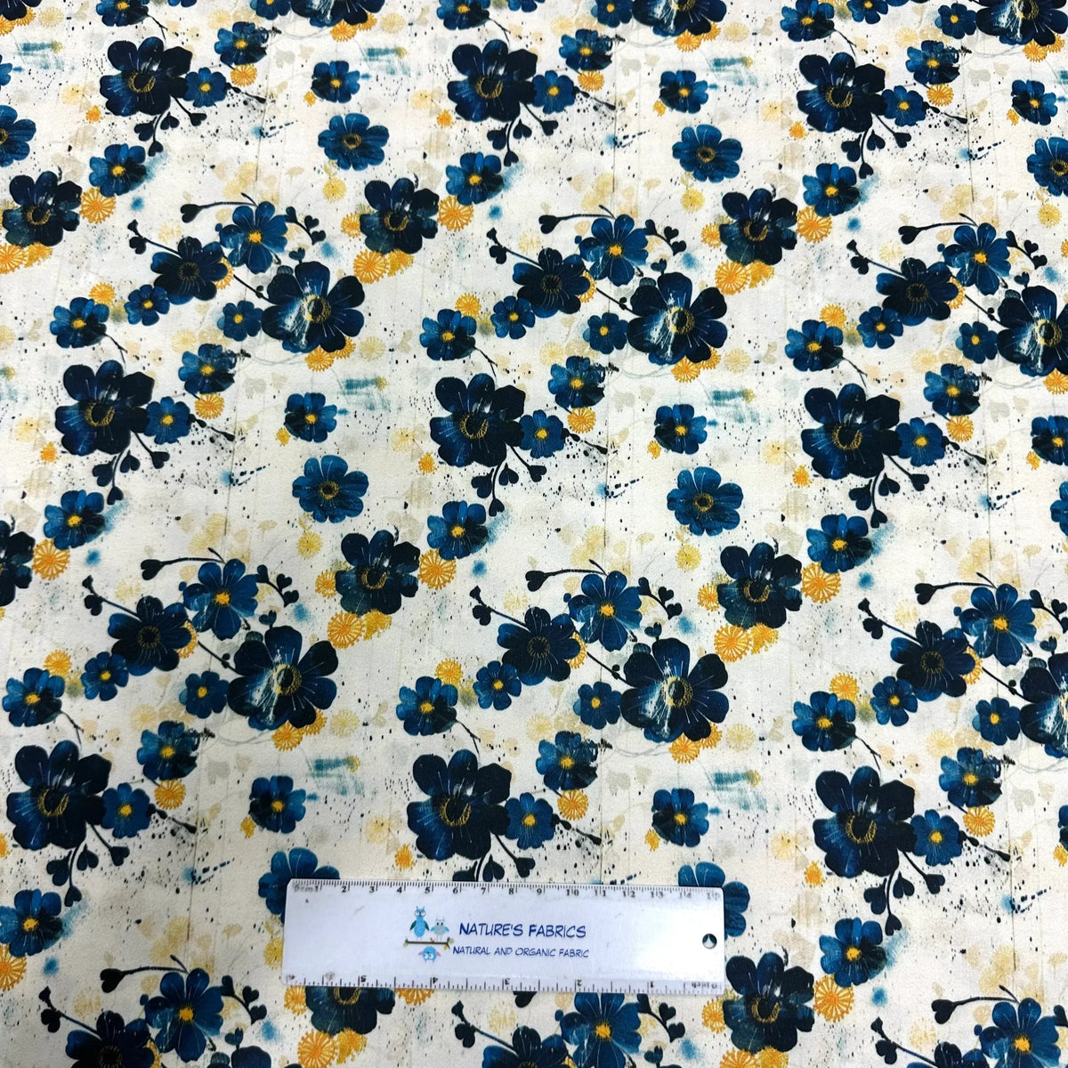 Nature's Fabrics blue floral print organic cotton fabric with yellow accents and ruler for scale