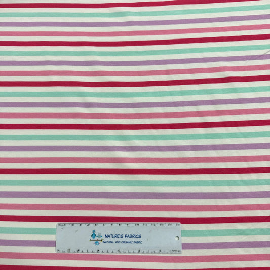 Nature's Fabrics striped fabric in pink, purple, and mint green with a ruler for scale.