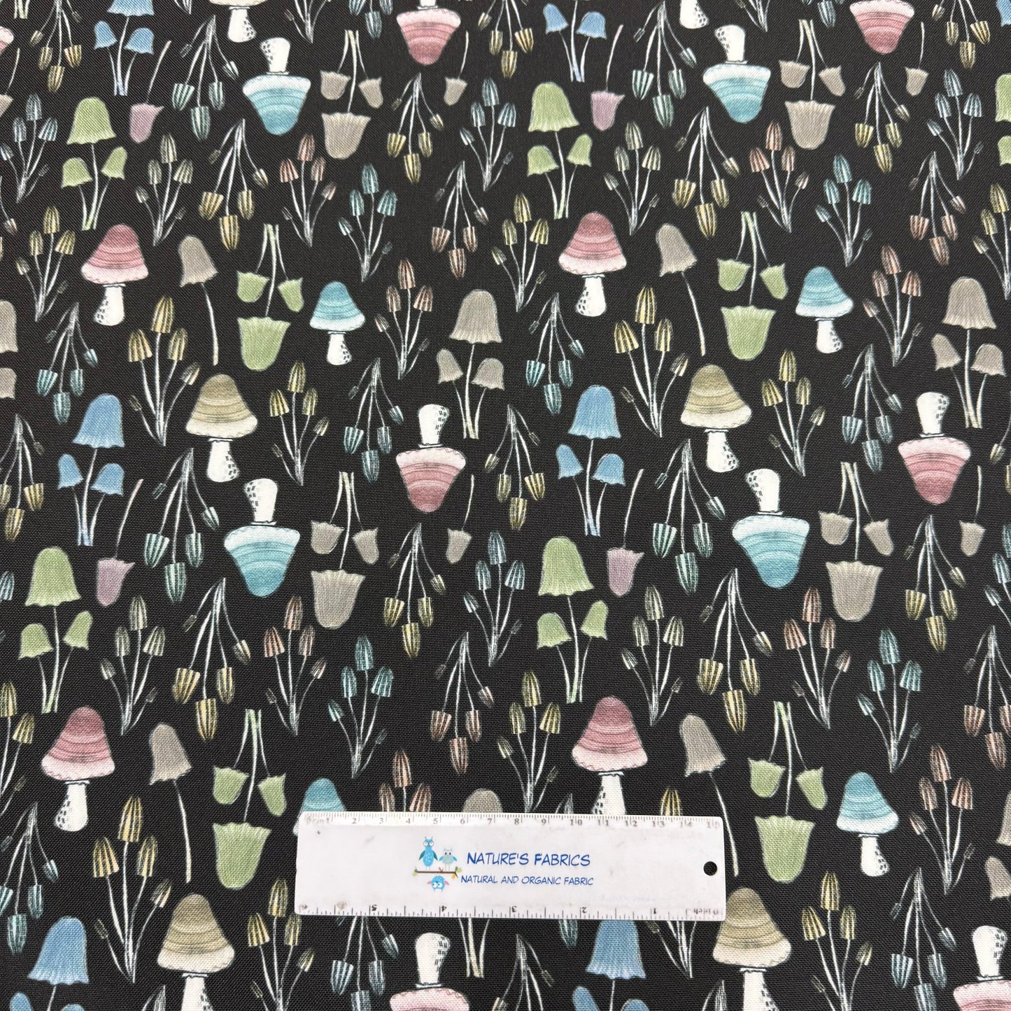 Nature's Fabrics mushroom print organic cotton fabric with colorful toadstools on black background