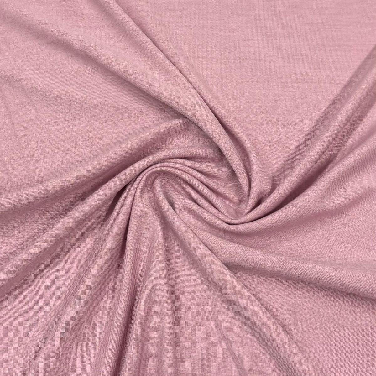 Nature's Fabrics dusty rose pink natural fabric draped in a swirl pattern.