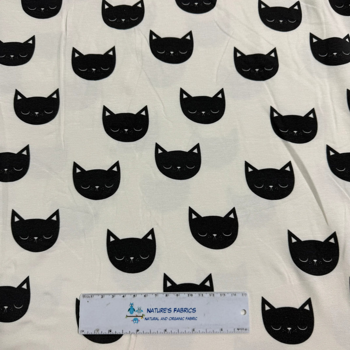 Black cat face print on white organic cotton fabric by Nature's Fabrics, natural and eco-friendly textile