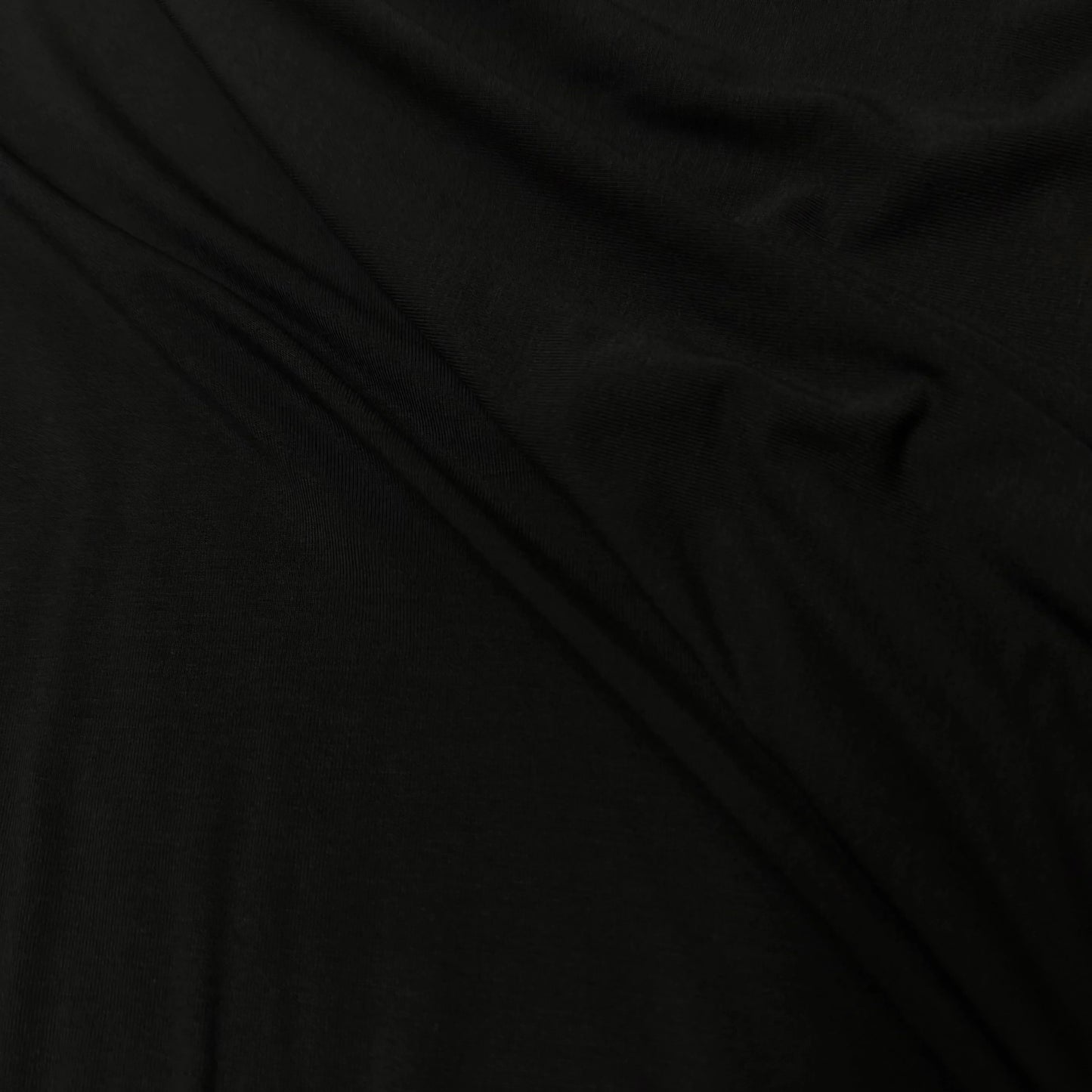 Solid black organic fabric with soft texture, ideal for sustainable apparel sewing projects