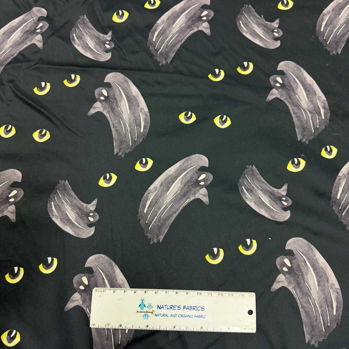 Nature's Fabrics ghost and yellow eye pattern on black organic cotton fabric