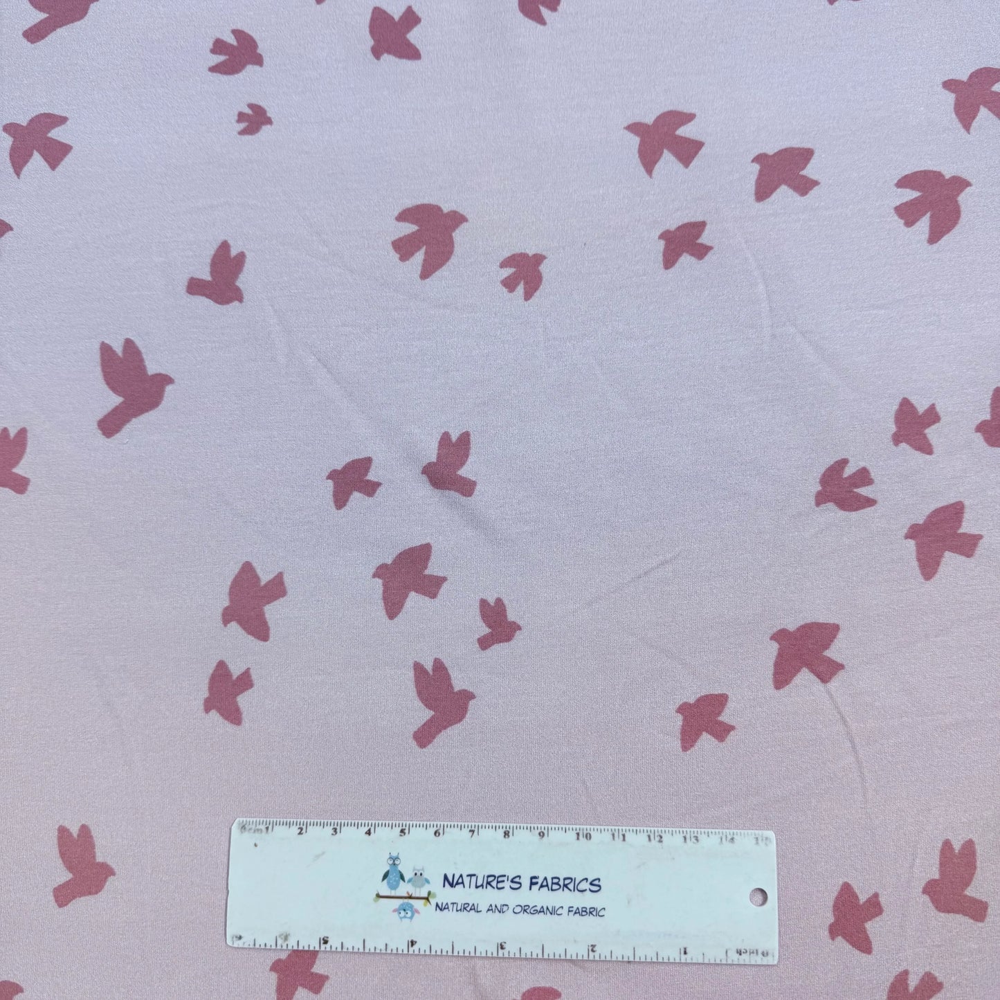 Nature's Fabrics organic cotton fabric with pink bird print, shown with ruler for scale