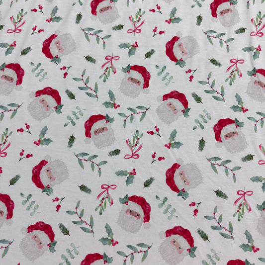 Nature's Fabrics Christmas fabric with Santa, holly, and bows on white background