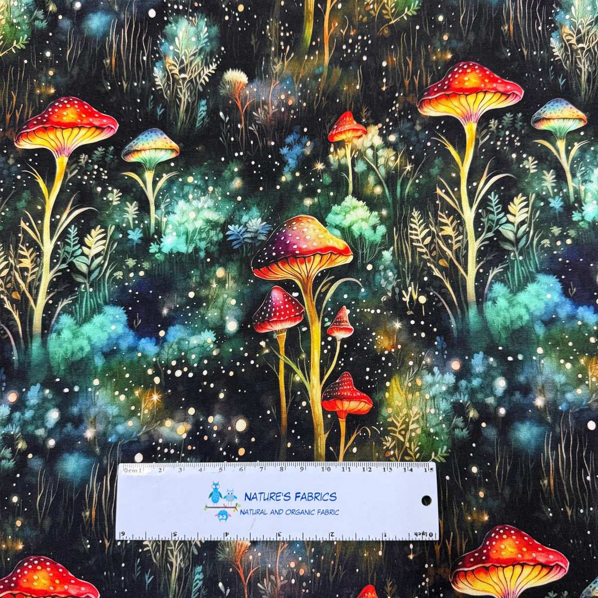 Nature's Fabrics organic fabric featuring a magical forest with colorful mushrooms and stars.