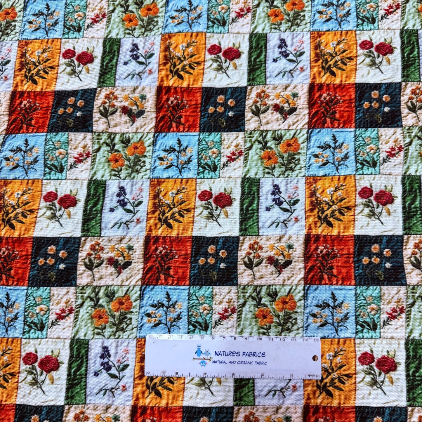 Nature's Fabrics floral patchwork cotton fabric with vibrant squares, perfect for quilting and sewing projects.