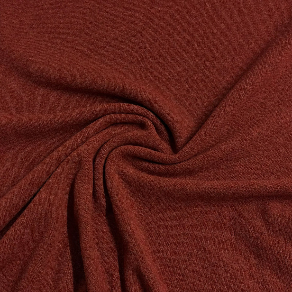 Nature's Fabrics rust-colored natural fabric with elegant folds and a soft texture.