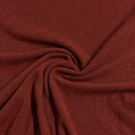 Nature's Fabrics rust-colored natural fabric with elegant folds and a soft texture.