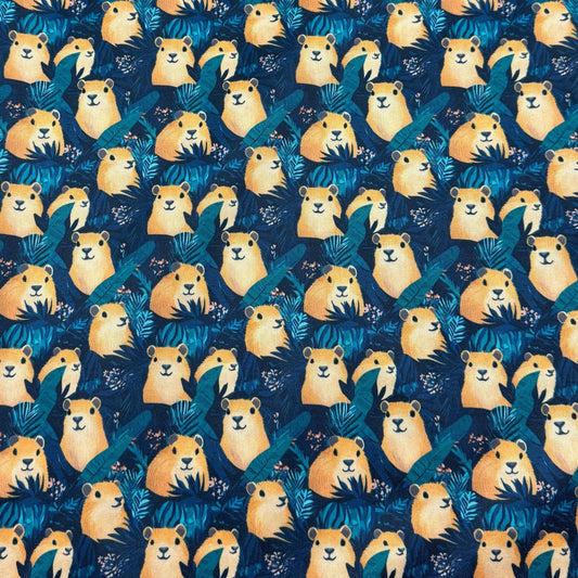 Nature's Fabrics blue organic cotton fabric with cute yellow capybara and tropical leaf pattern