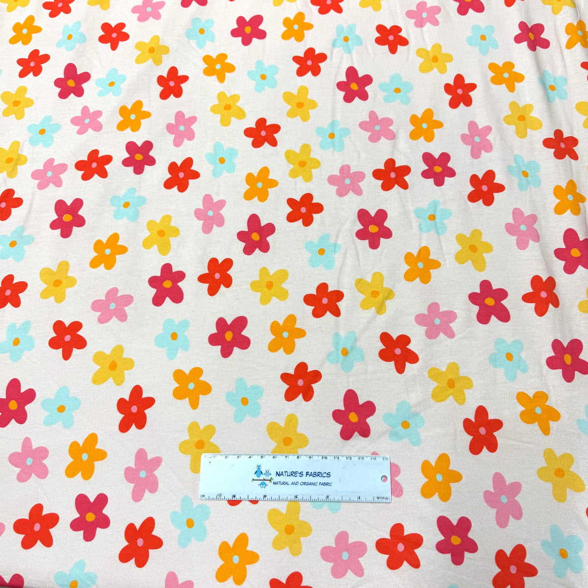 Nature's Fabrics white organic cotton fabric with colorful floral print and measuring ruler