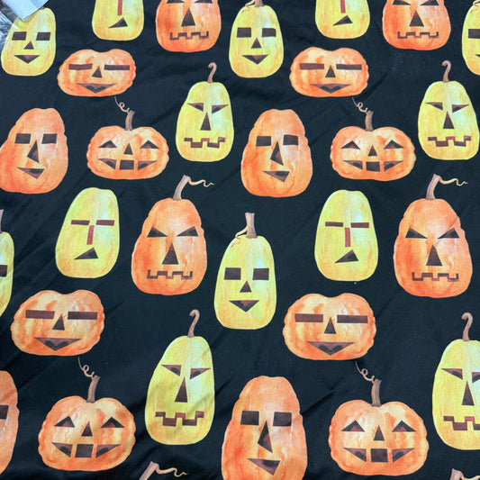 Nature's Fabrics black fabric with orange and yellow jack-o-lantern pumpkin print