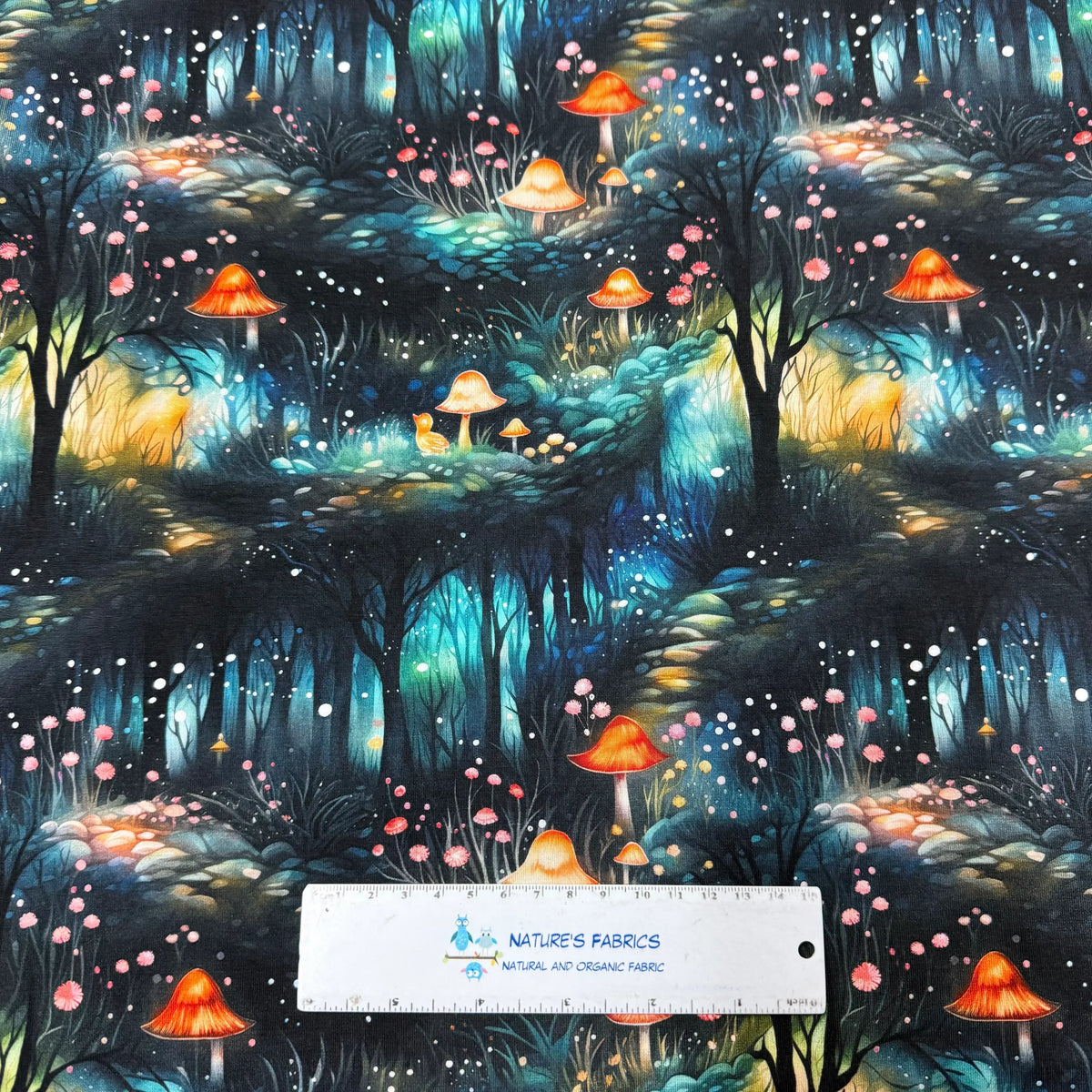 Nature's Fabrics enchanted forest print with glowing mushrooms, pink flowers, and fairy lights on natural fabric