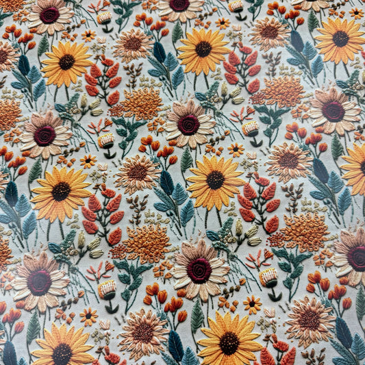 Nature's Fabrics floral embroidered fabric featuring yellow and orange sunflowers.