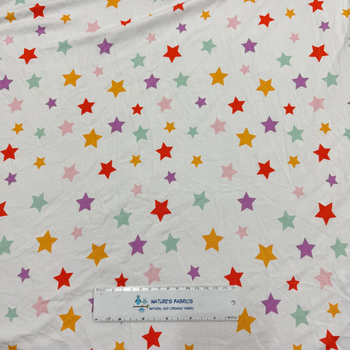 Nature's Fabrics organic cotton fabric with colorful rainbow stars pattern, natural and eco-friendly textile by the yard
