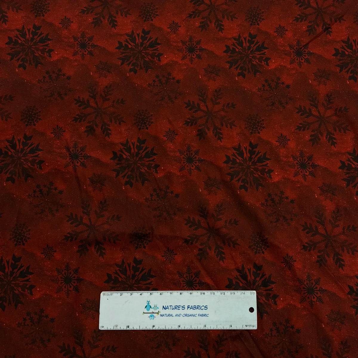 Rust red fabric with black snowflakes by Nature's Fabrics, natural organic cotton yardage