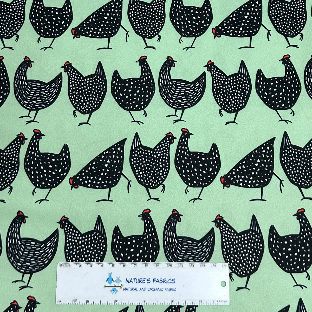 Black spotted chicken print on mint green fabric by Nature's Fabrics, natural organic cotton yardage