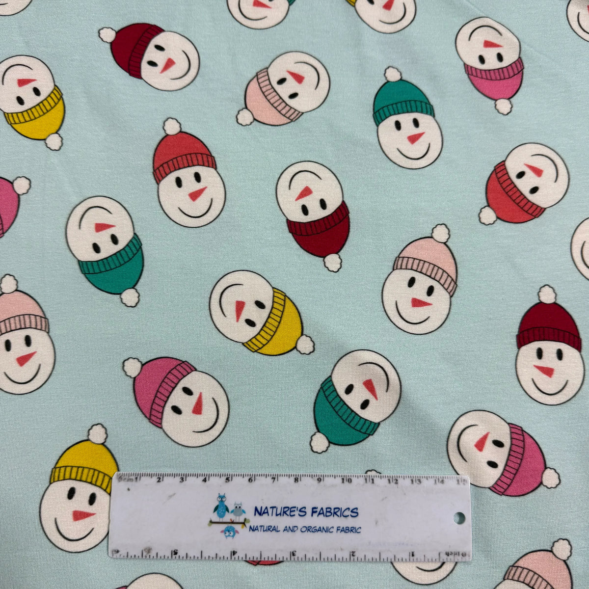 Snowman print fabric by Nature's Fabrics, colorful hats on light blue background
