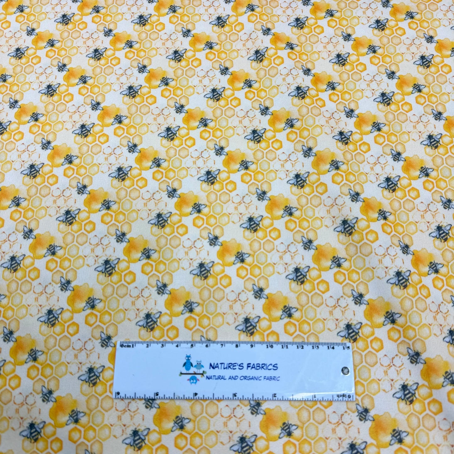 Nature's Fabrics bee and honeycomb pattern organic cotton fabric with ruler for scale