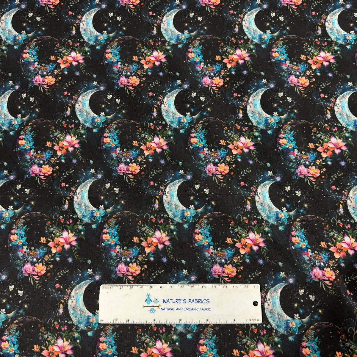Nature's Fabrics: black fabric with crescent moons, pink & blue flowers, stars, and a ruler for scale